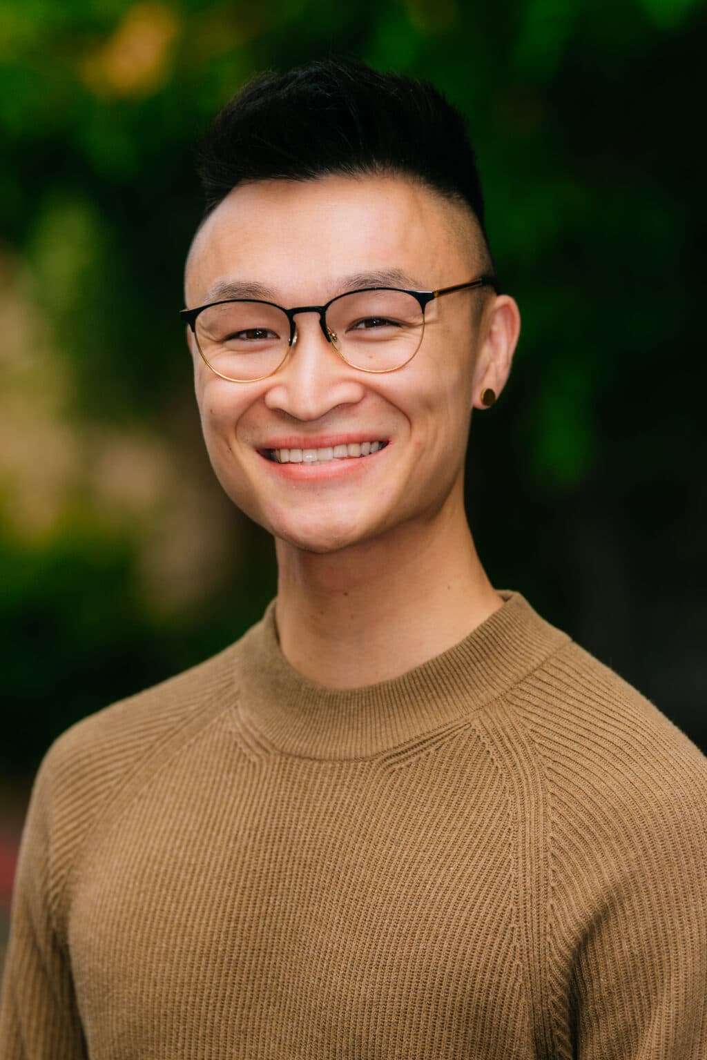 Corporate headshot of a smiling professional man outdoors for a photography agency.