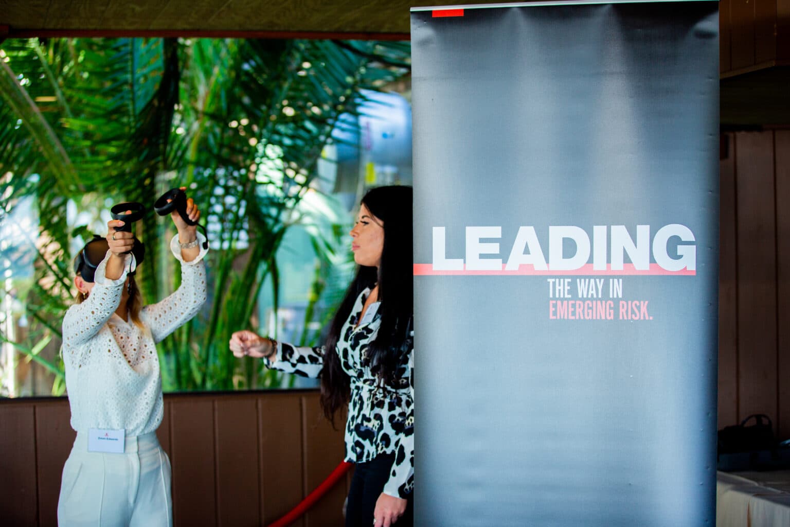 Woman using VR headset at conference with banner for corporate event.