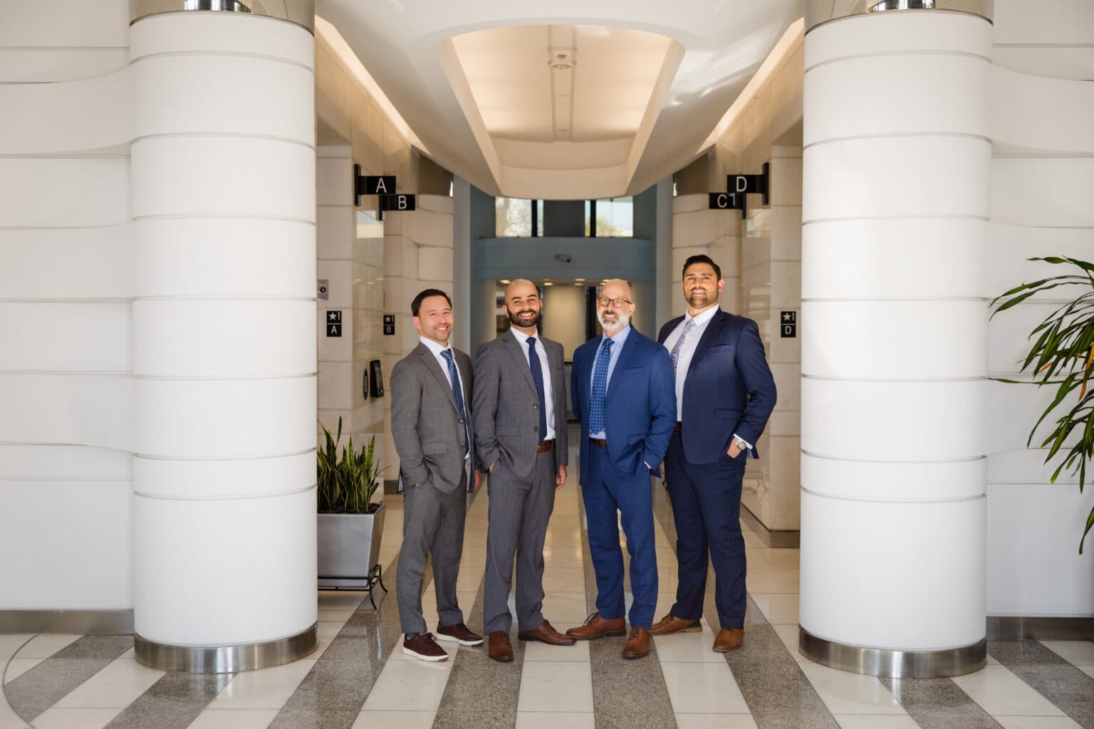 Corporate team of professionals standing together in a modern office lobby